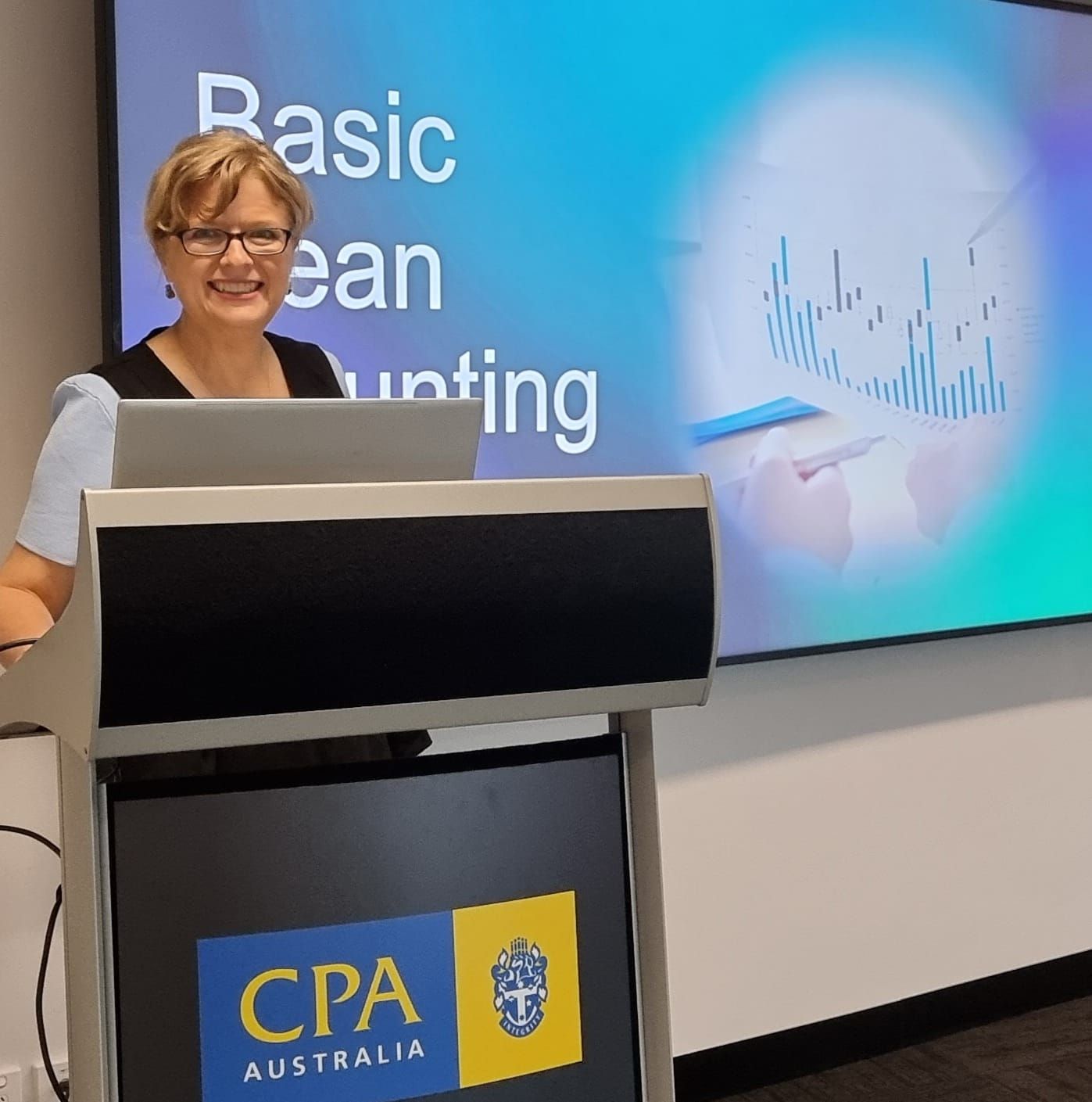 A Woman Standing In front of a Business with Flowers  — Adding Value CFO Pty Ltd in Palmerston, NT