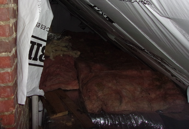 Pile of moldy fiberglass batt insulation in an attic
