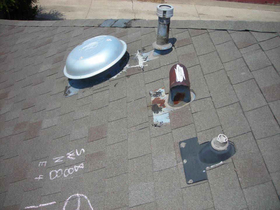 View of a rooftop with vents, a fan, and flashing on asphalt shingles.
