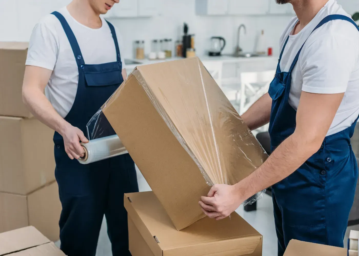 A professional mover carefully placing a wrapped furniture piece into a secure storage unit.
