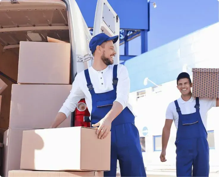 A professional moving team carefully wrapping and lifting furniture inside a home.