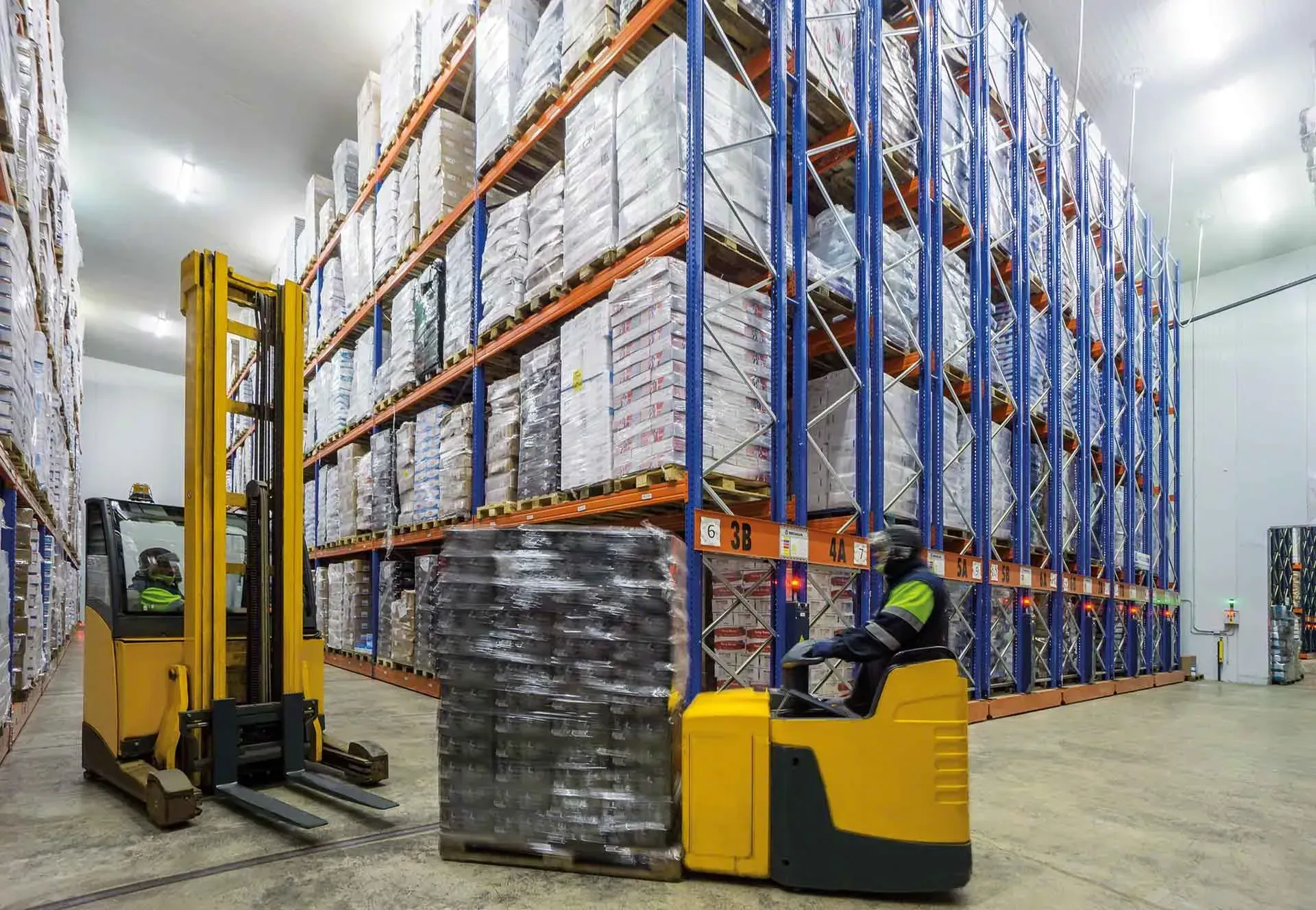 A man is driving a forklift in a warehouse.