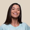 A woman in a light blue sweater is smiling for the camera.