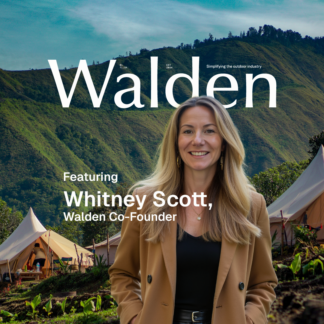 Whitney Scott, Walden Co-Founder, smiles in front of a glamping site with green mountains.