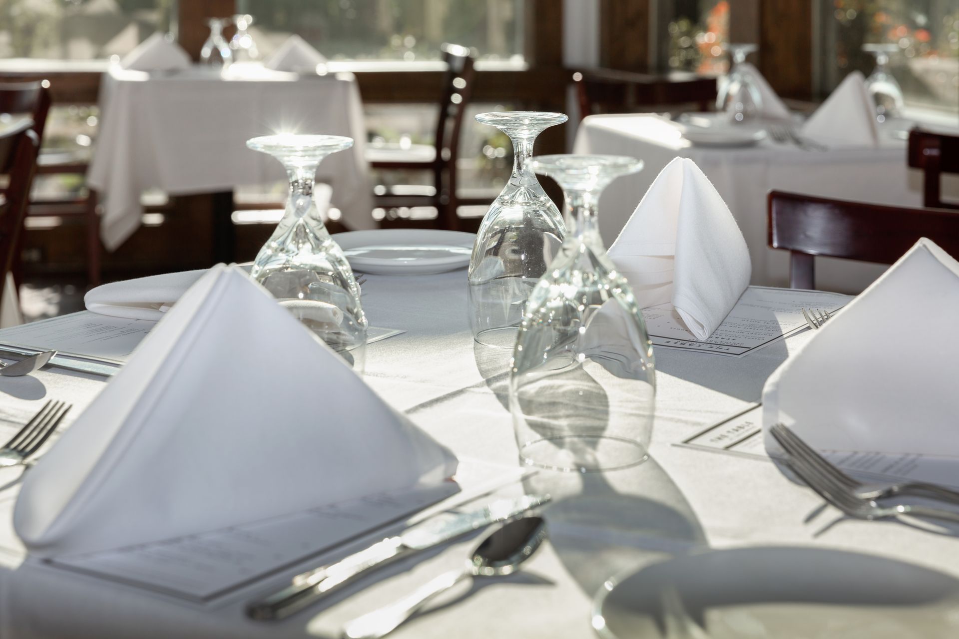 A restaurant table with glasses and napkins on it