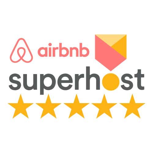 A couple looks at a smartphone together while standing outside a building on a sunny day.