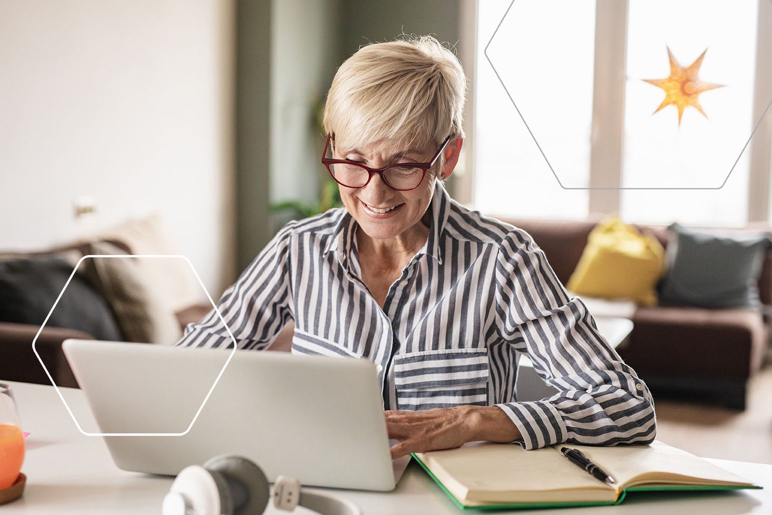 a middle-aged woman smiling and working on a laptop