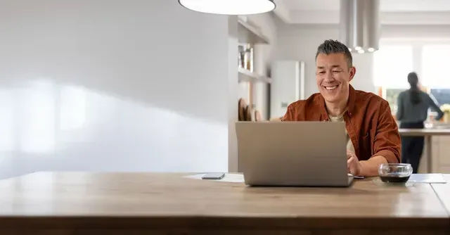 A laptop computer is sitting on a table with a blue background.