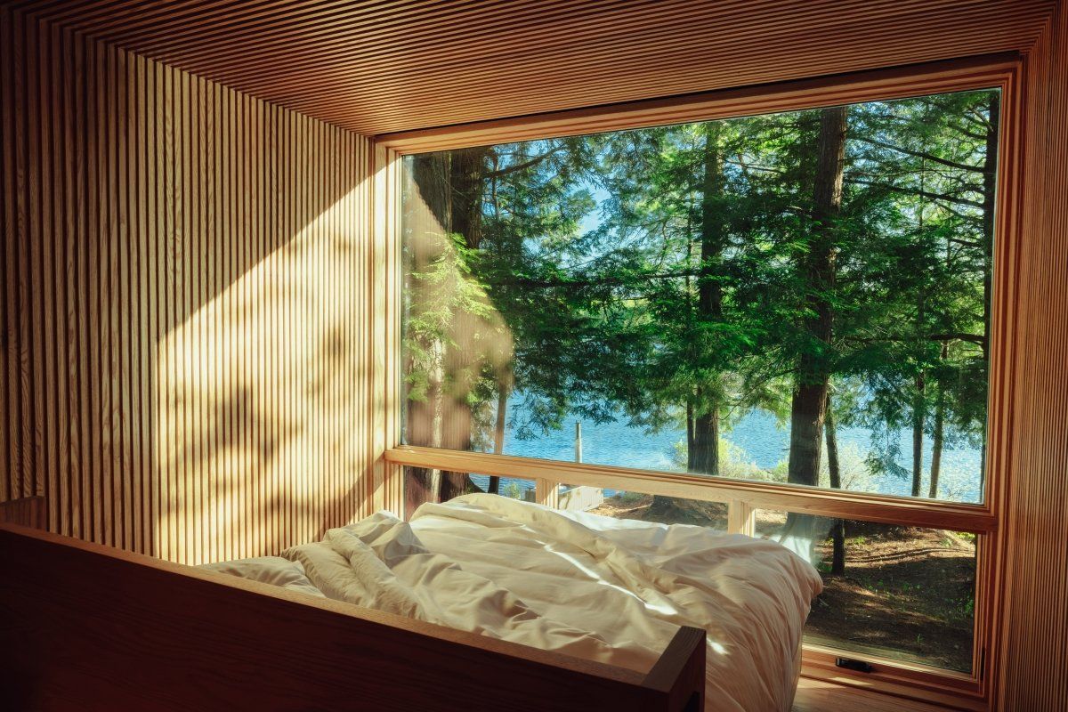 A bedroom with a bed and a window overlooking a lake.