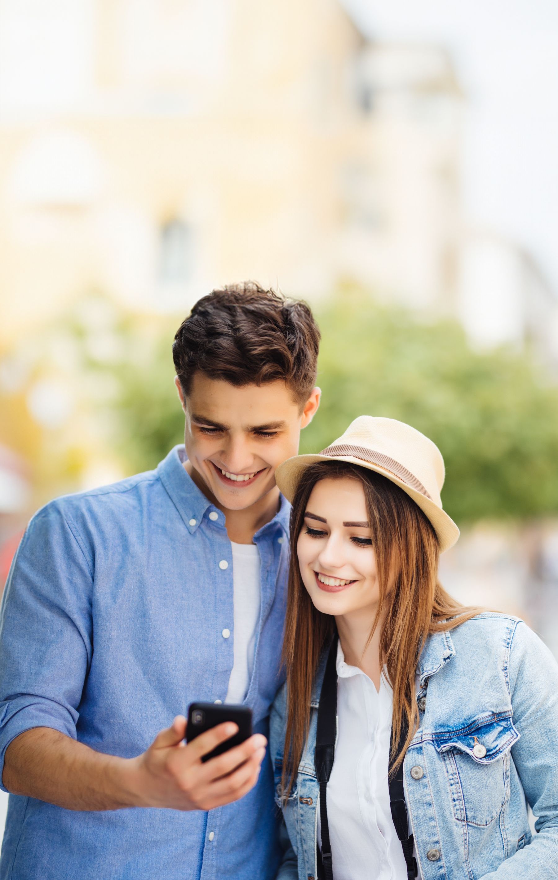 A man and a woman are looking at a cell phone together.