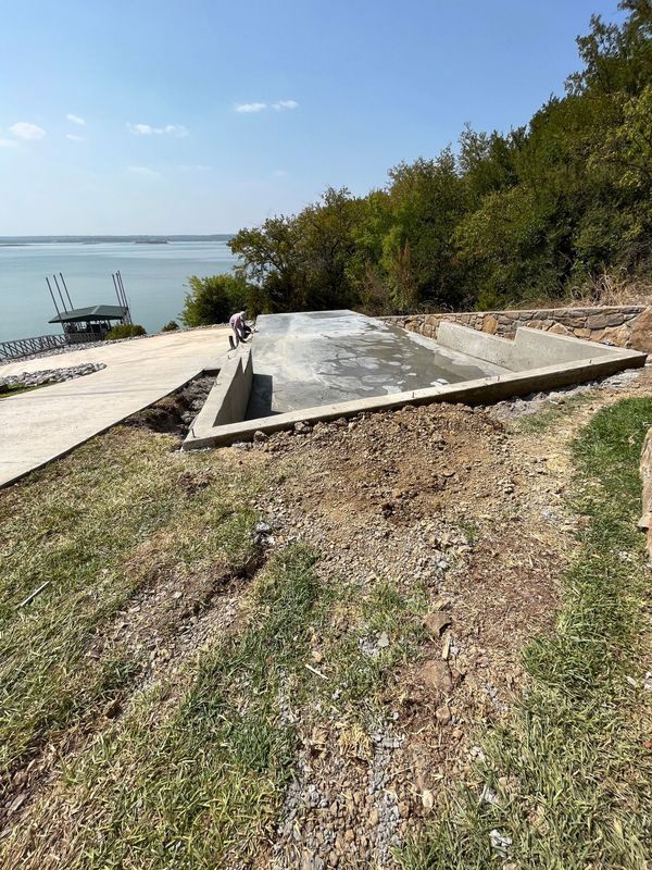 A concrete foundation is being built next to a lake.