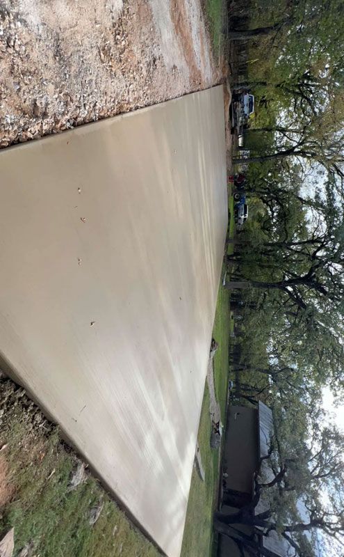 A concrete driveway is being built in the backyard of a house.