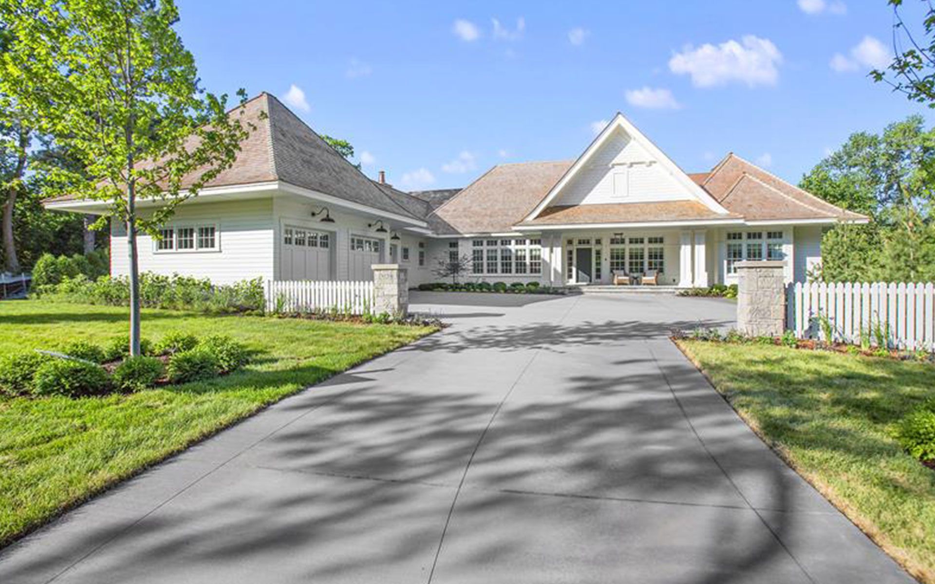 A large white house with a driveway leading to it.