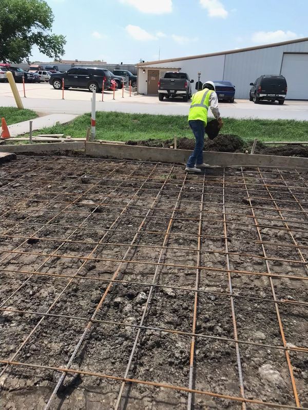 A man in a yellow vest is working on a construction site.