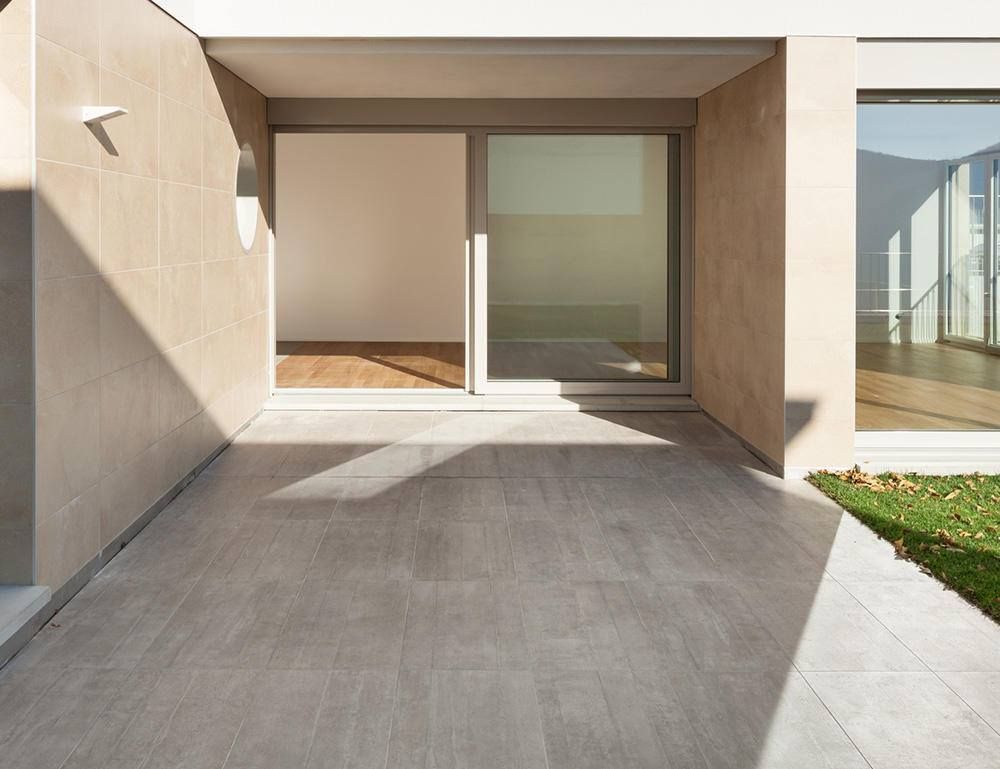 A patio with a sliding glass door leading to a room