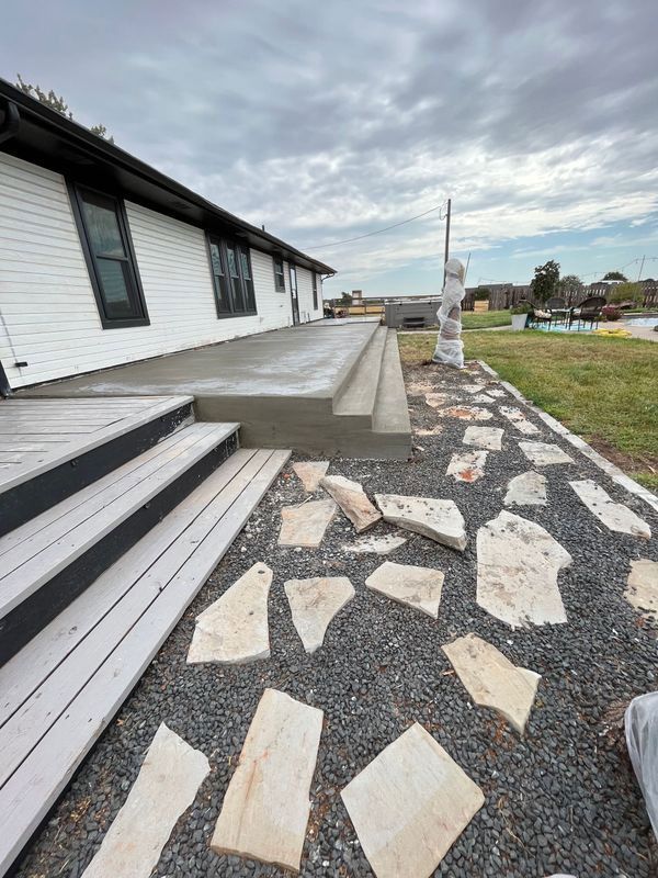 A house with a walkway leading to it and a deck.