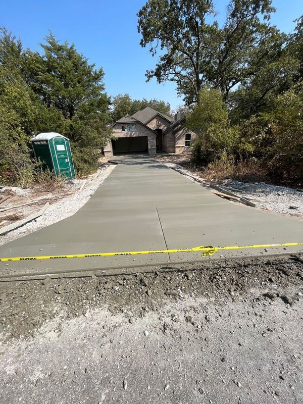 A concrete driveway is being built in front of a house.
