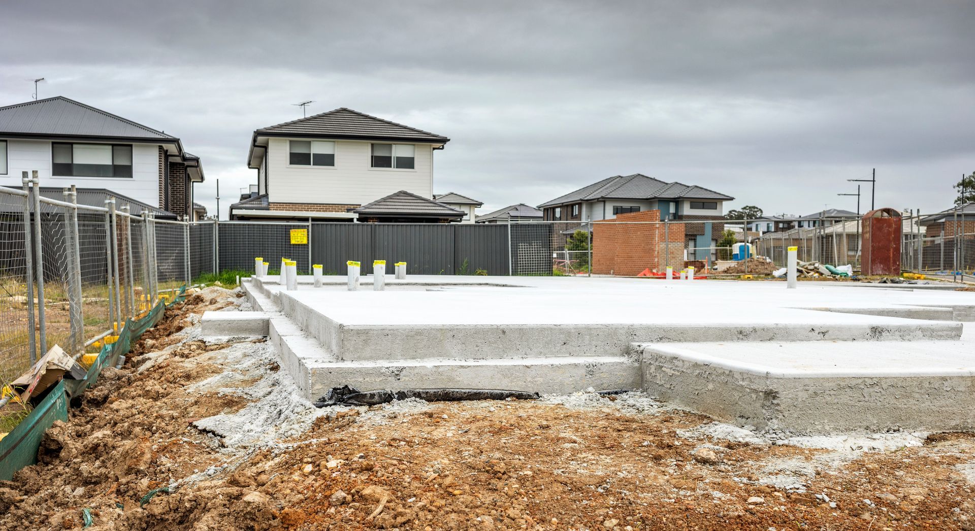 A construction worker is laying bricks on a wall at a construction site.