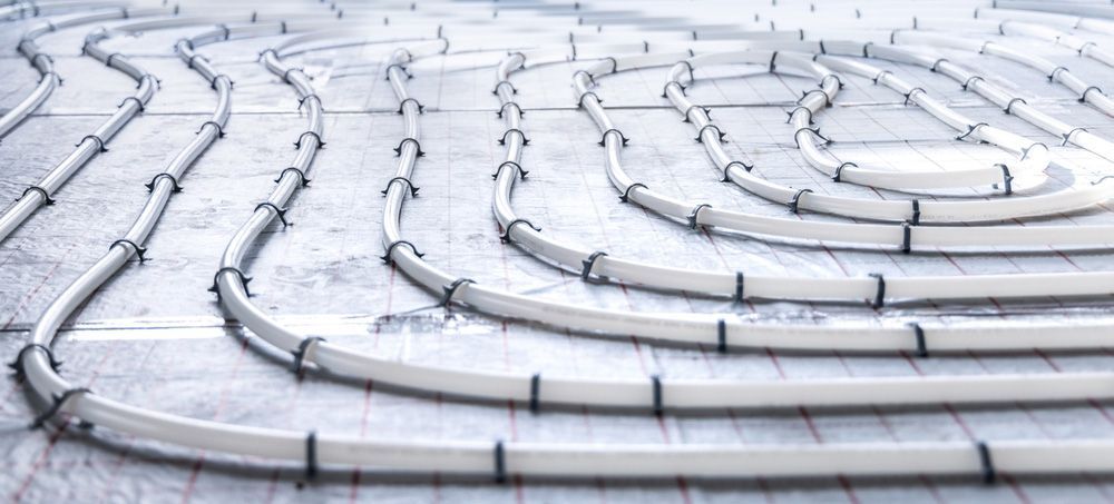 A room in a house under construction with pipes and electrical wires.