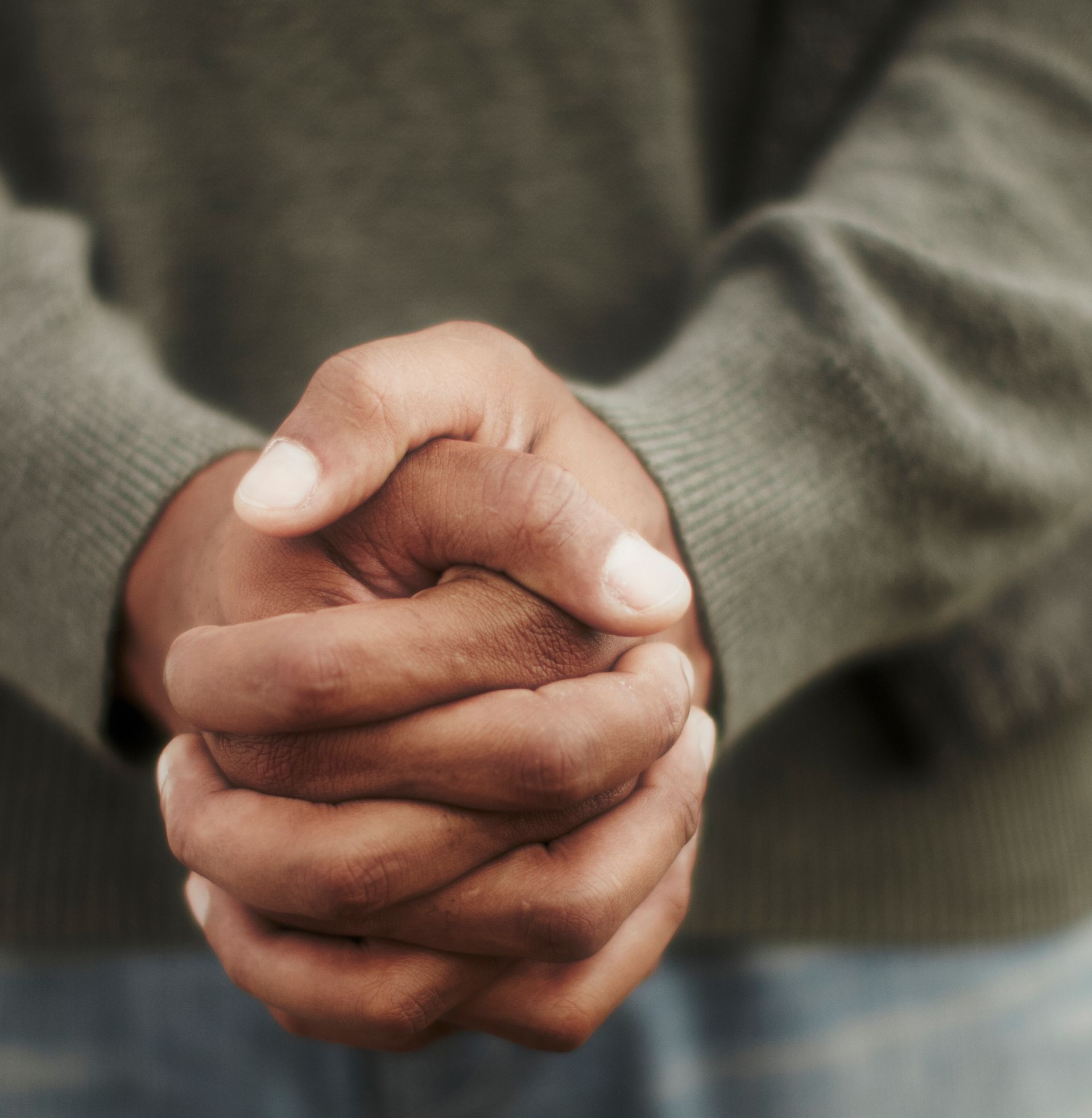 Folded hands symbolizing vulnerability, reflection, and emotional healing in therapy