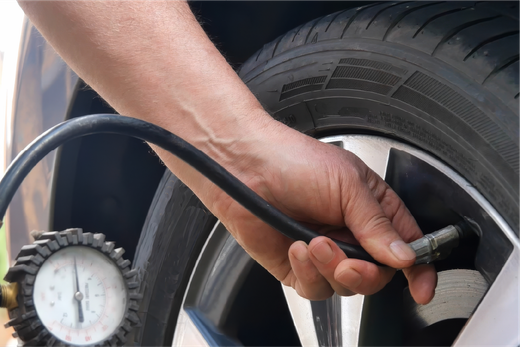 A person is inflating a tire with a hose.