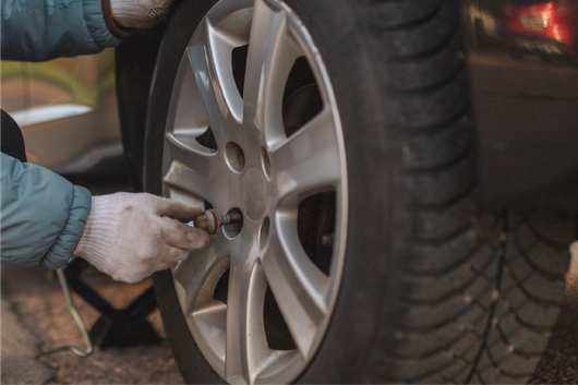A person is changing a tire on a car.