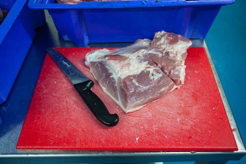 Some of the fresh and locally sourced meat ready to be cut into smaller pieces by one of the team, in order for it to then be ground. Delabole, Cornwall. 17.11.15