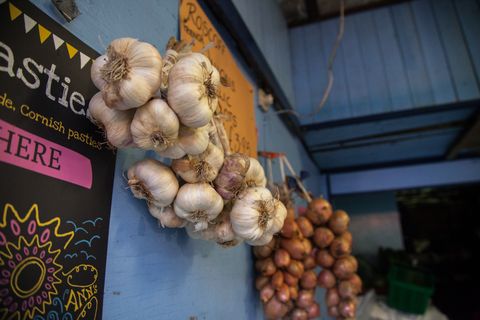 Fresh garlic and onions hung in the sheltered part of the stall. Perran-ar-Worthal, Cornwall. 30.10.15.