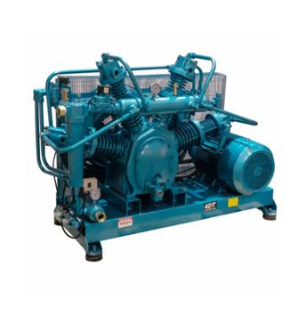 Compresor de aire industrial azul. Múltiples cilindros, tuberías y manómetros sobre una base metálica.