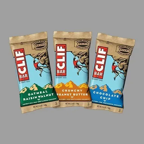 Three clif bars are stacked on top of each other on a gray background.