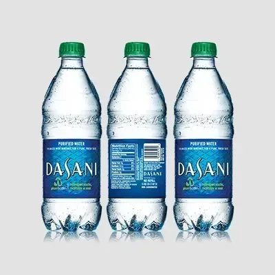 Three bottles of dasani water are sitting next to each other on a table.