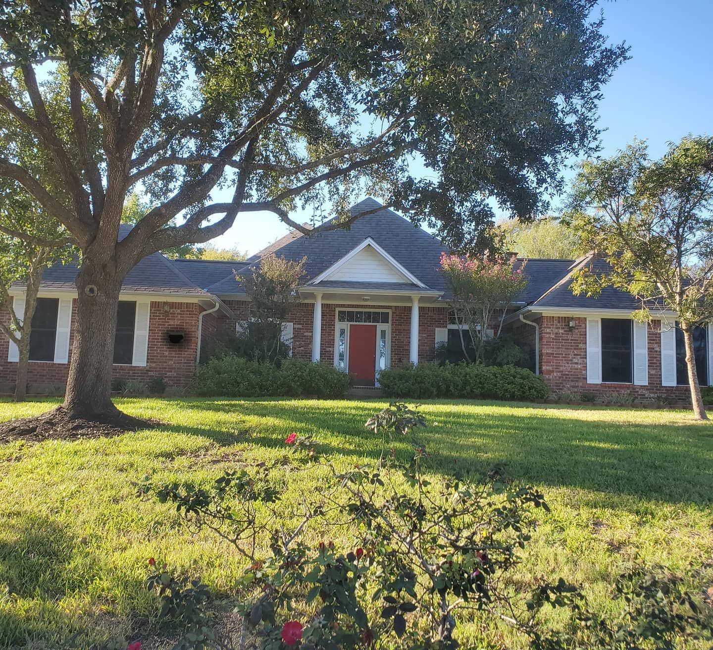 A brick house with a red door and white trim