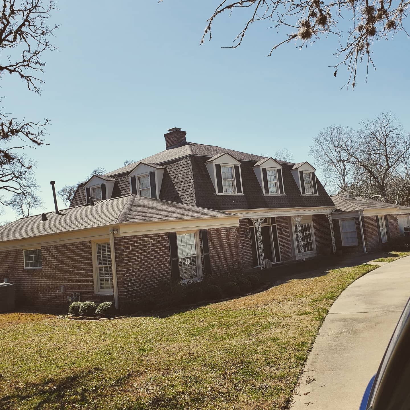 A large brick house with a gray roof and white trim