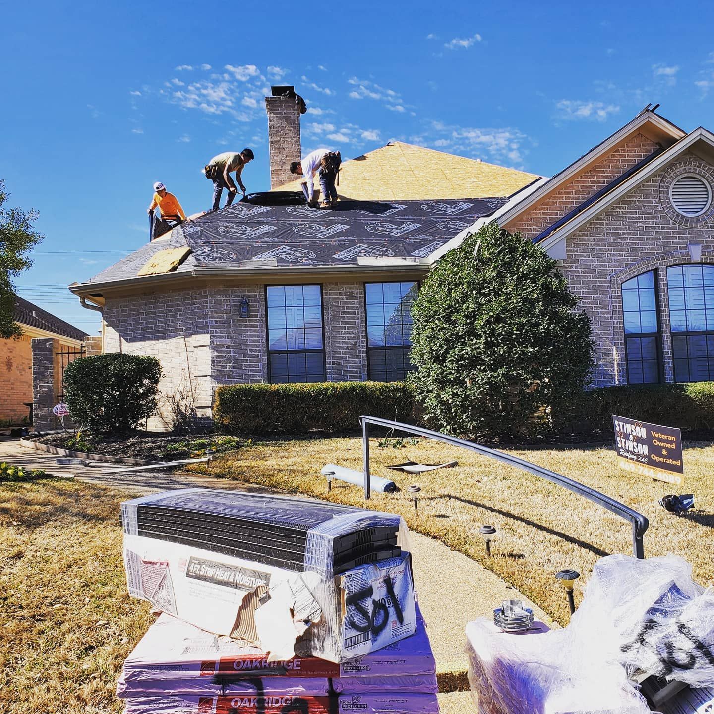 A group of men are working on the roof of a house.