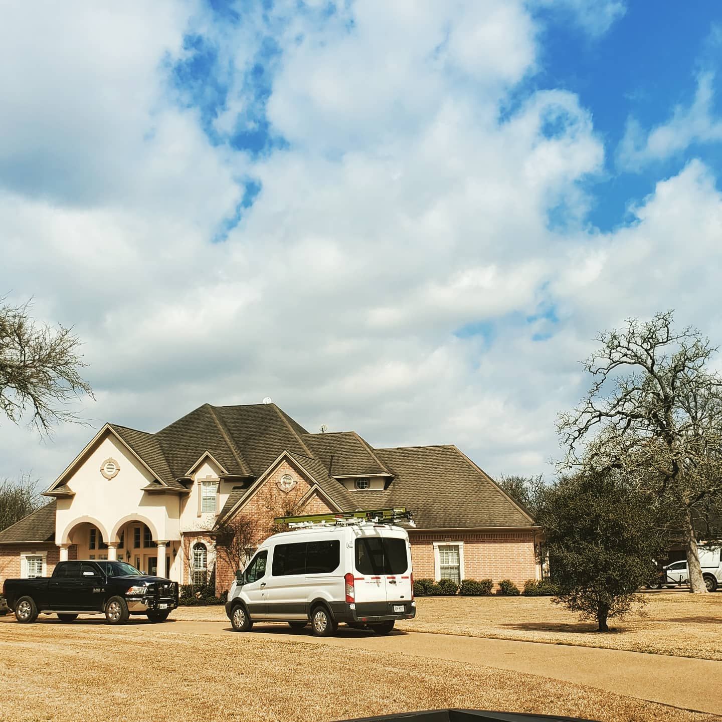 A white van is parked in front of a large house