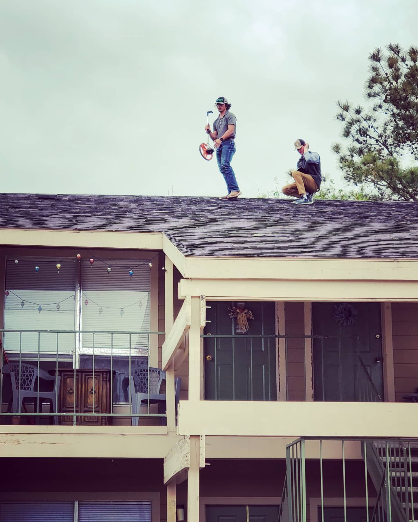 Two men are standing on the roof of a building