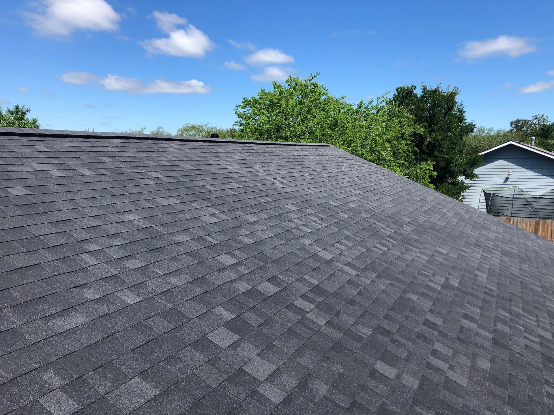 A black roof with a blue sky in the background