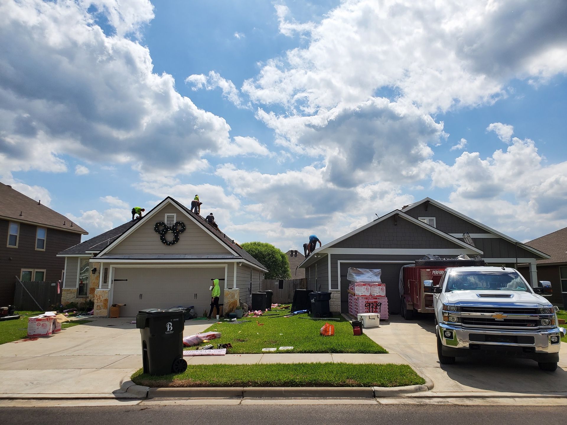 A white truck is parked in front of a house that is being remodeled.