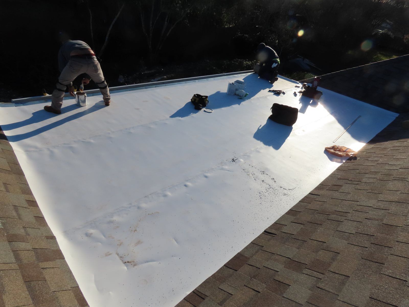 A man is working on a roof with a white sheet of paper