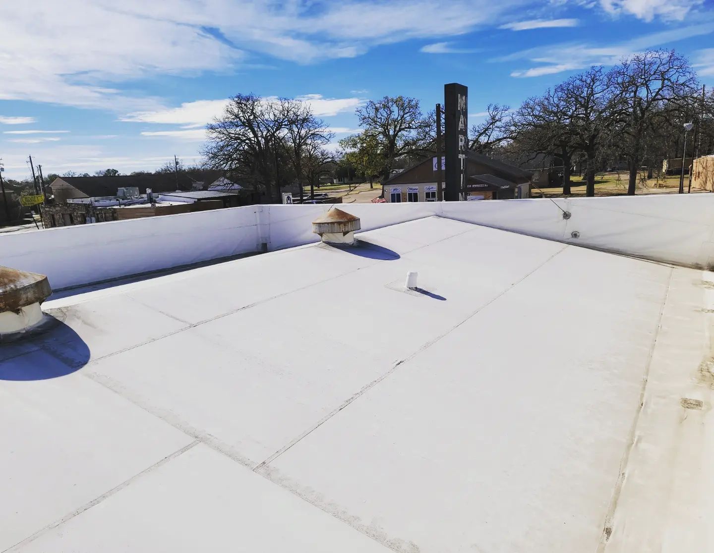 A white roof with a chimney on top of it.