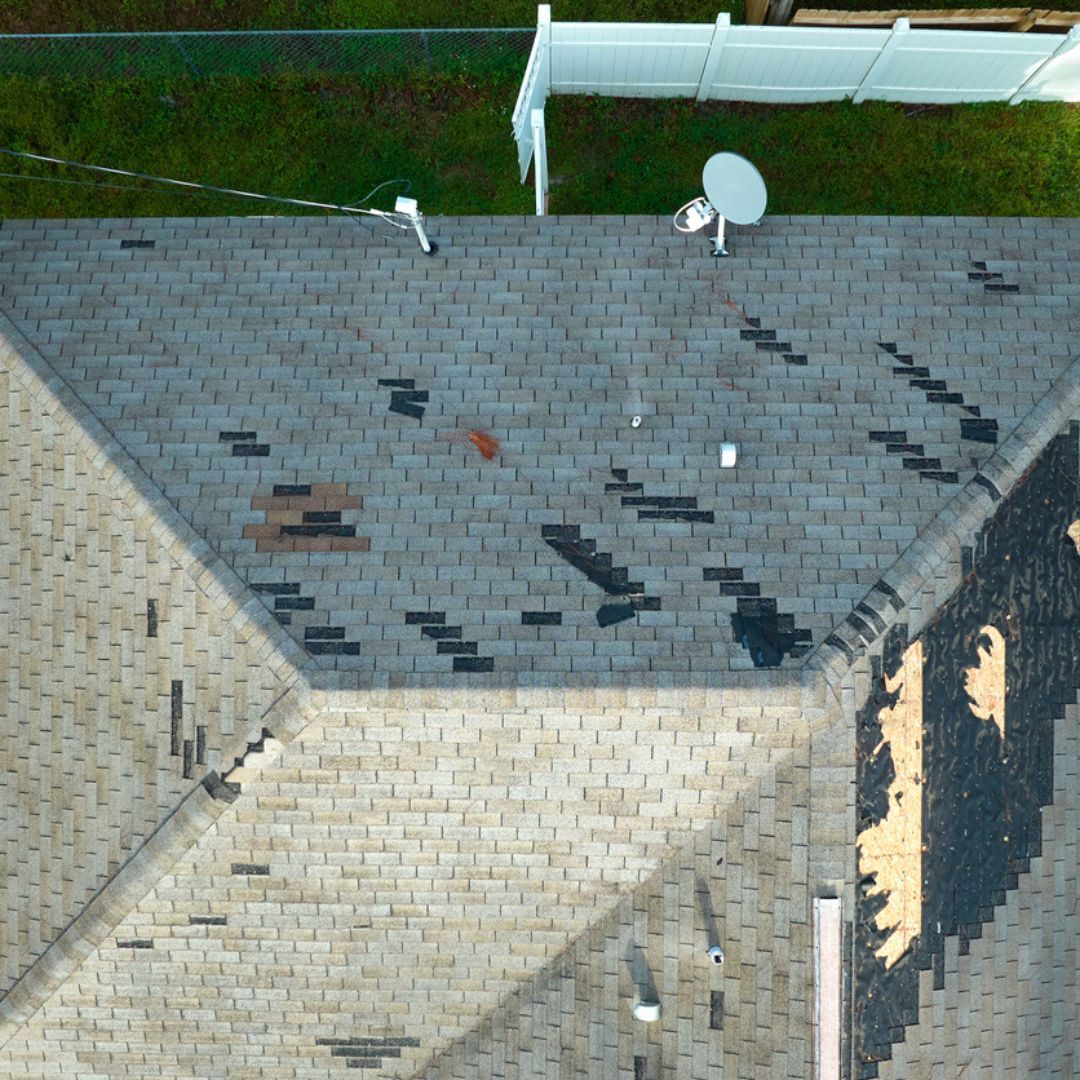 An aerial view of a roof with a white fence in the background