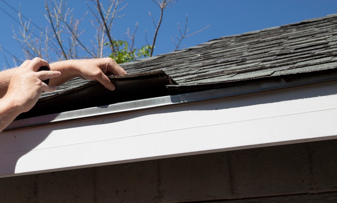 A person is working on the roof of a house.