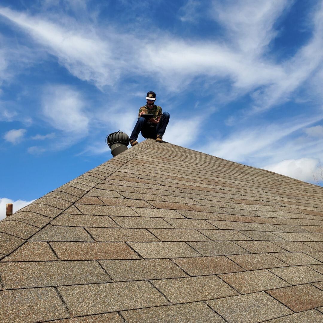 A man is sitting on top of a roof.