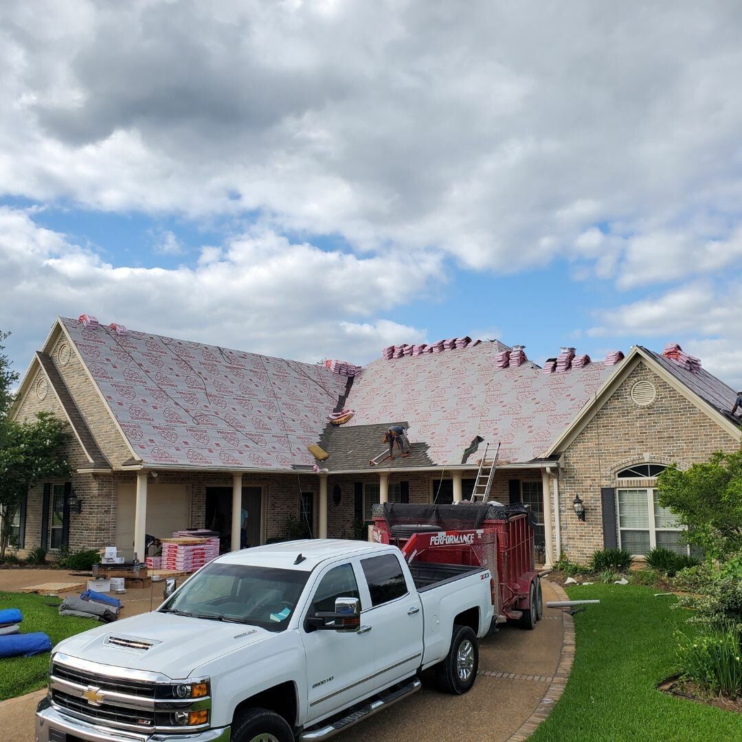 A white truck is parked in front of a house that is being remodeled.