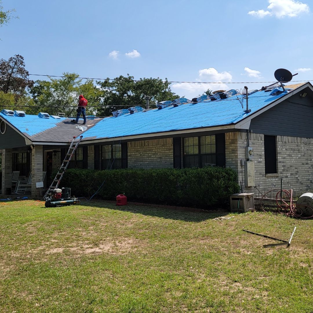 A house with a blue roof is being remodeled.