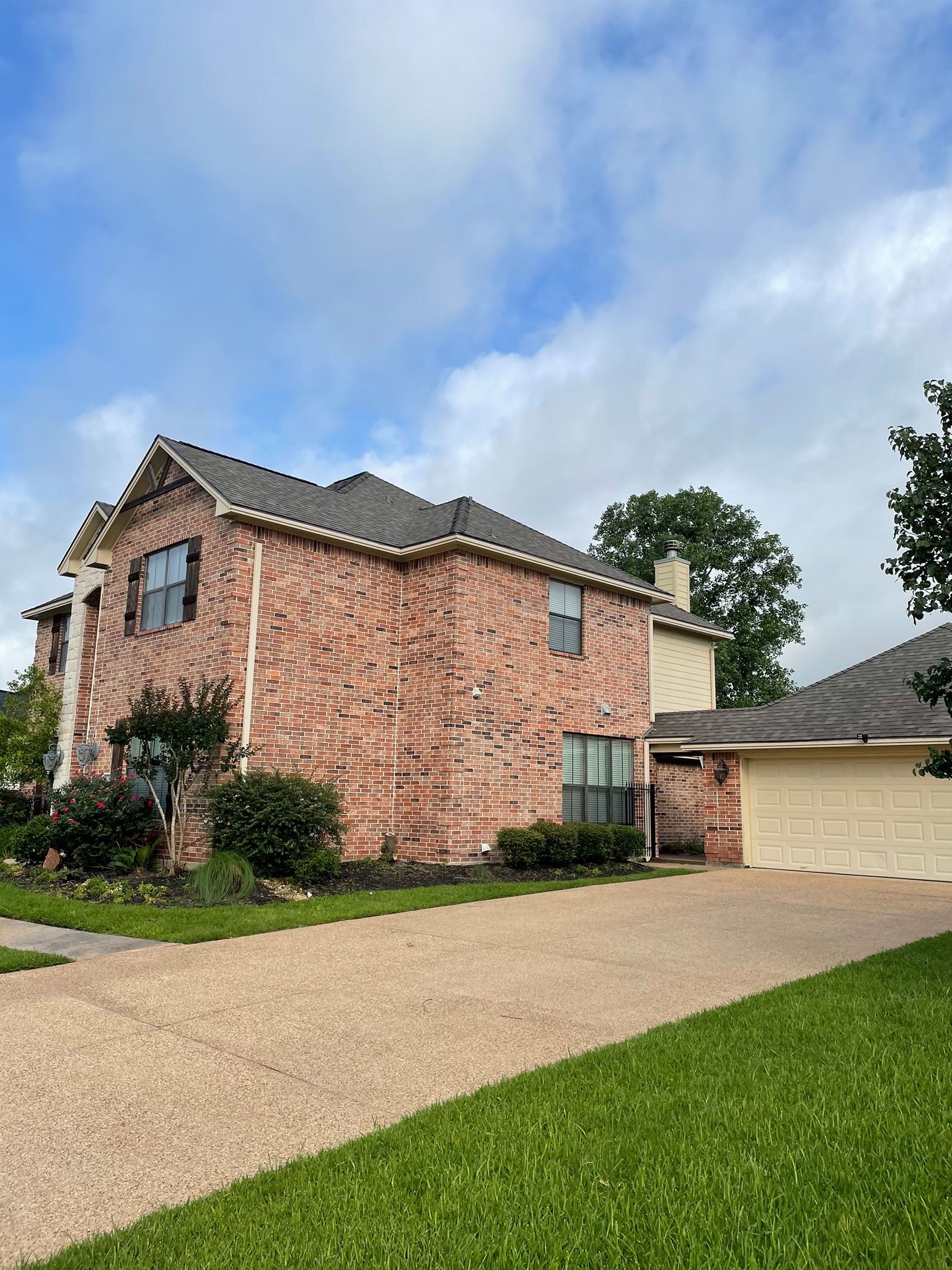 A large brick house with a garage and a driveway.