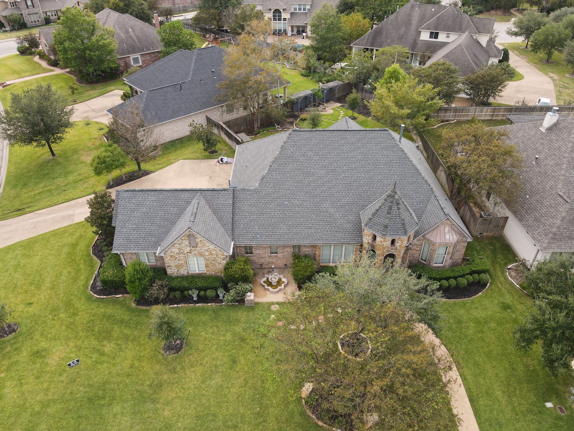An aerial view of a large house in a residential area.