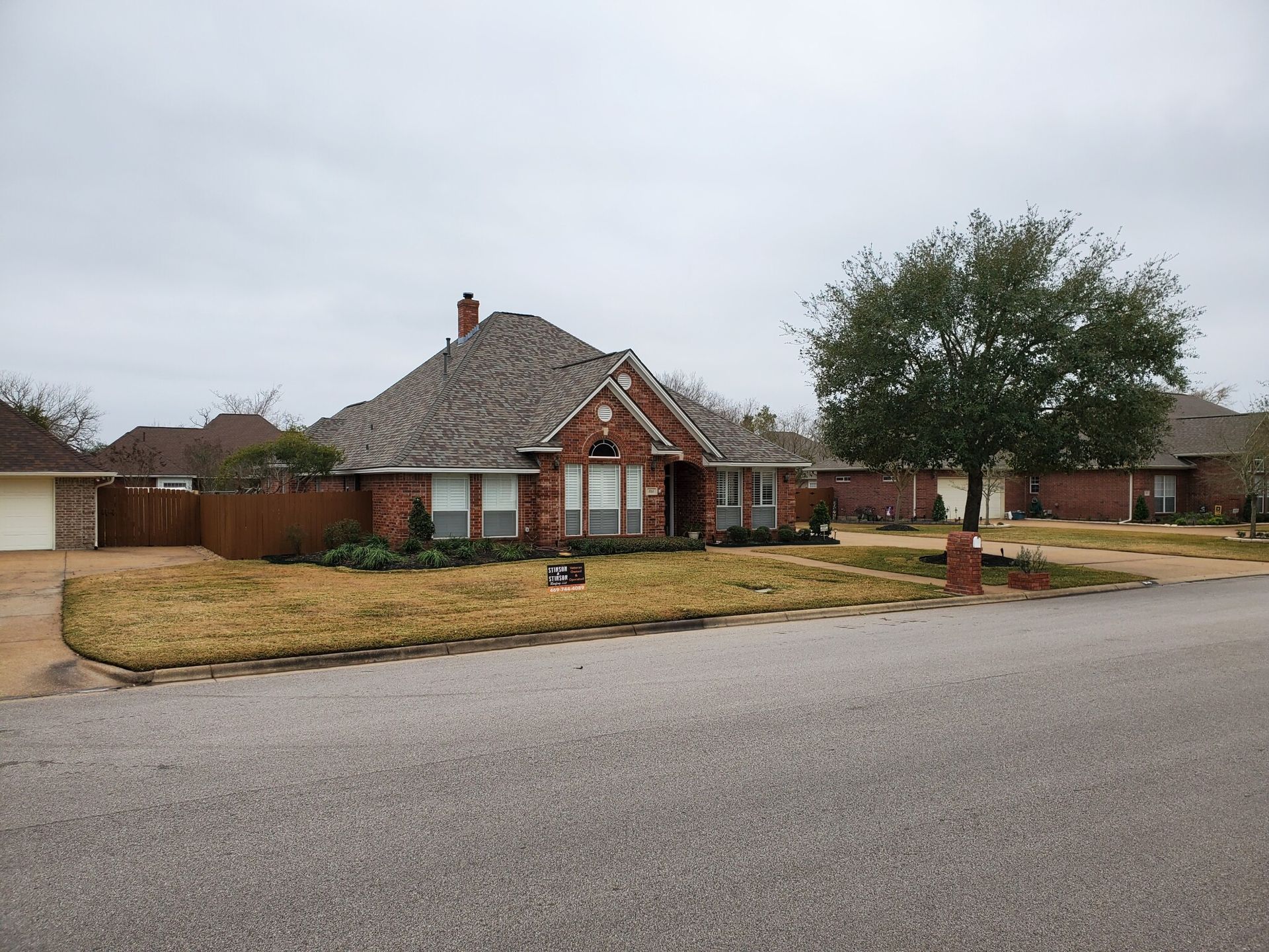 A brick house with a tree in front of it