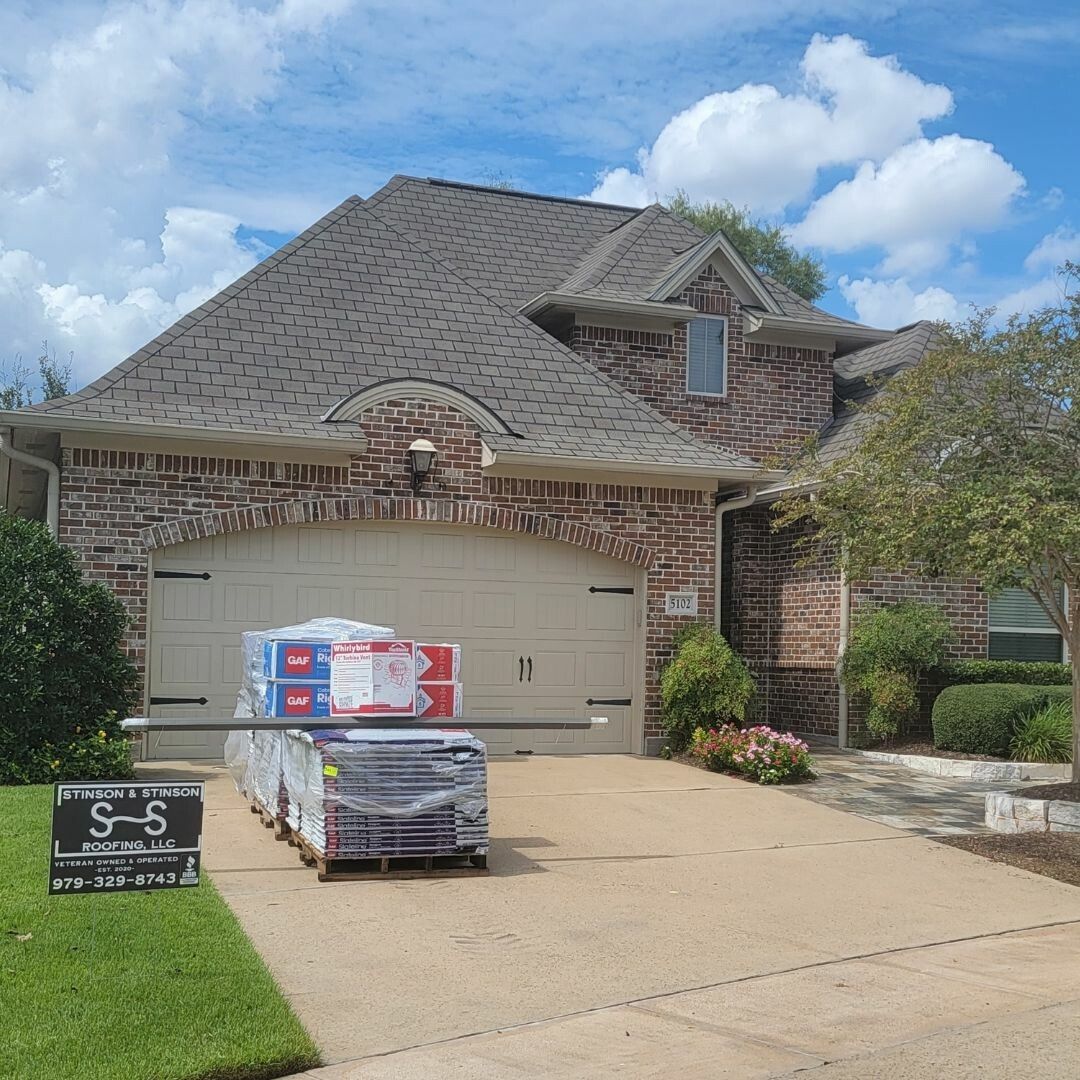 A brick house with a car parked in front of it.