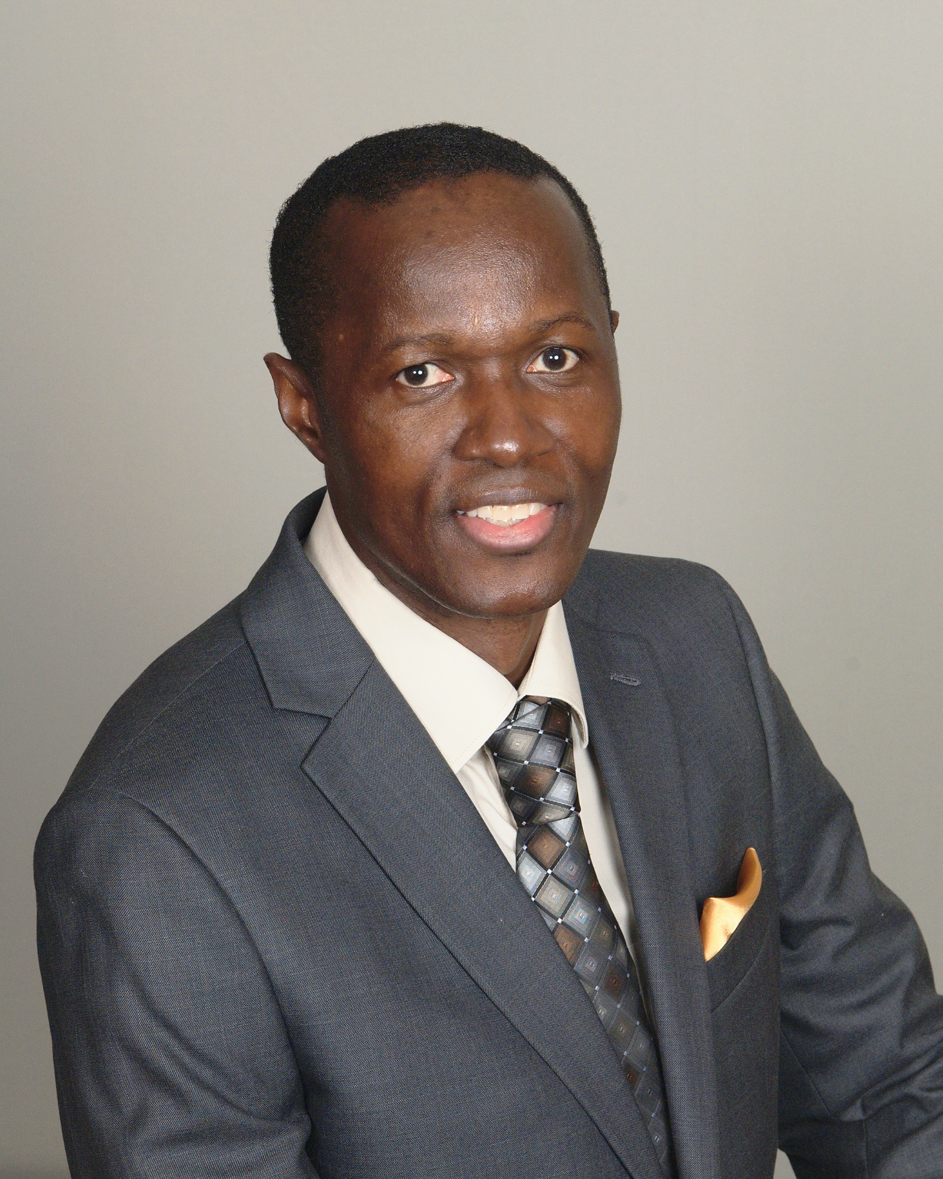 A man in a suit and tie is smiling for the camera.
